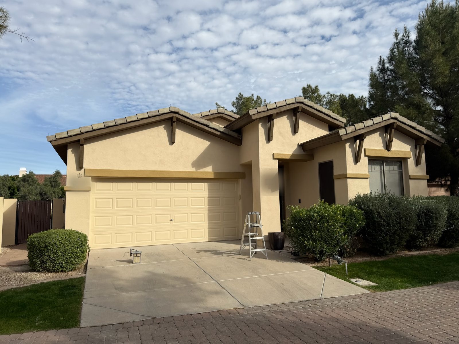Wider view of the same home, showing the painted garage door, entry and trim bands