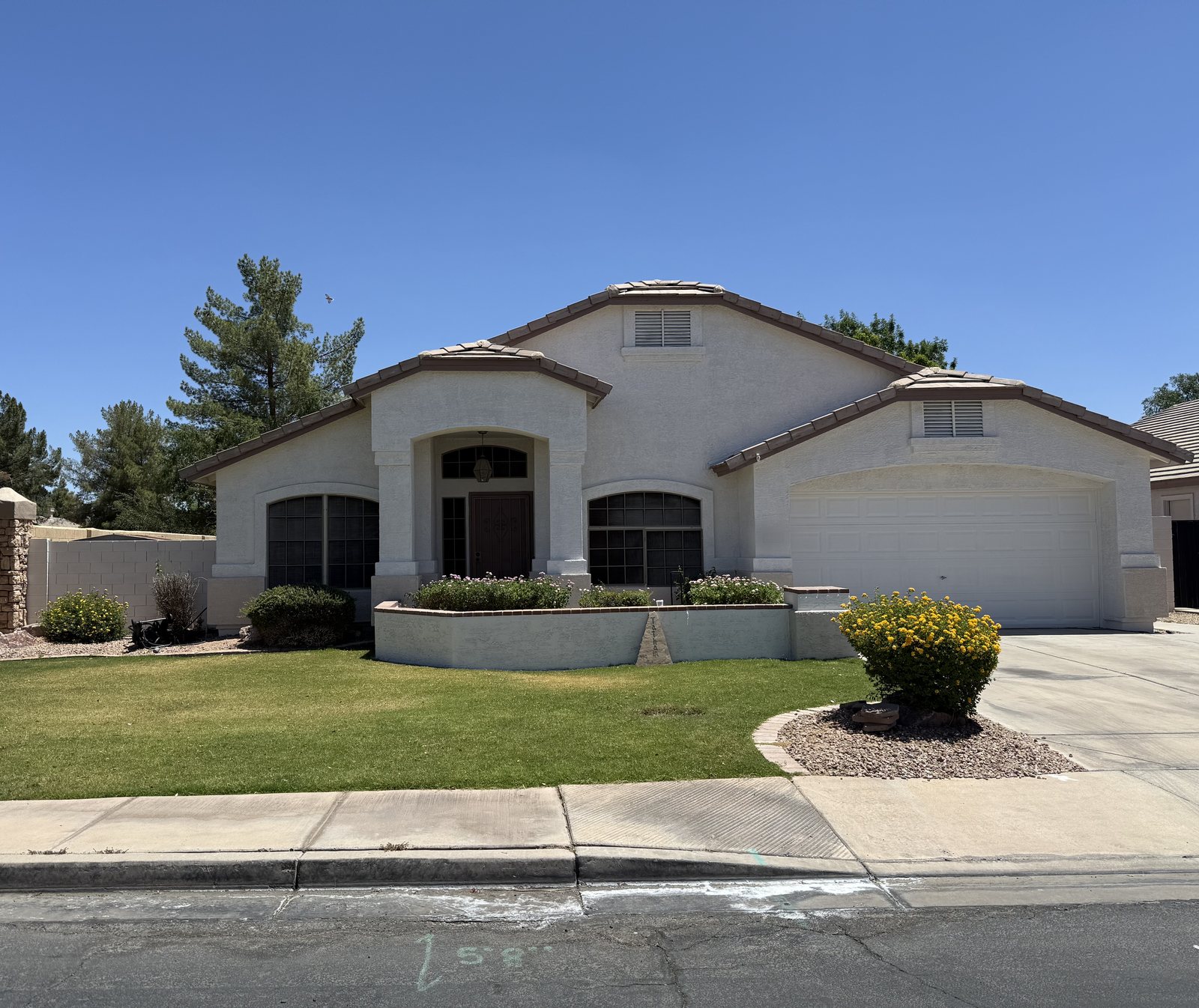 Single-story Arizona home painted by Happy Brush Painters &mdash; off-white stucco with matching trim, arched entry and a tile roof