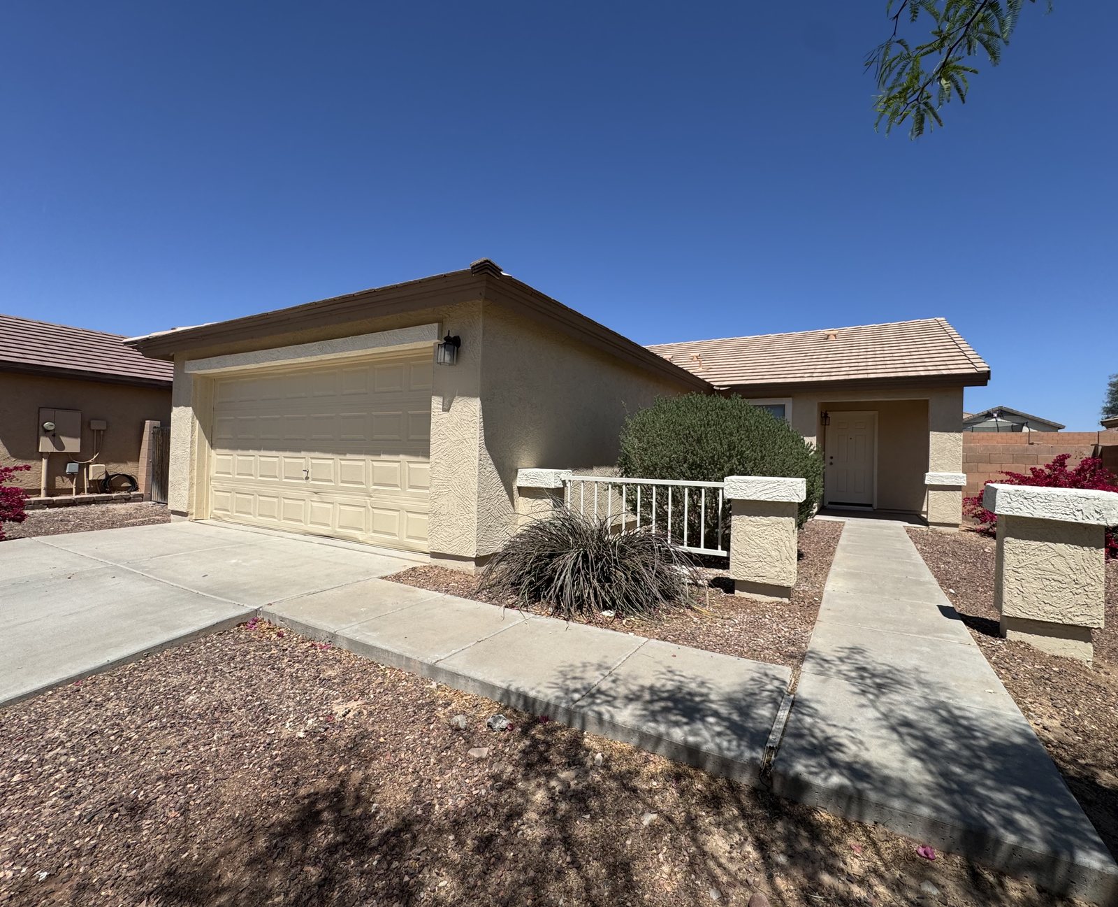 Tan single-story Arizona home painted by Happy Brush Painters &mdash; stucco body with a matching garage door and a tile roof