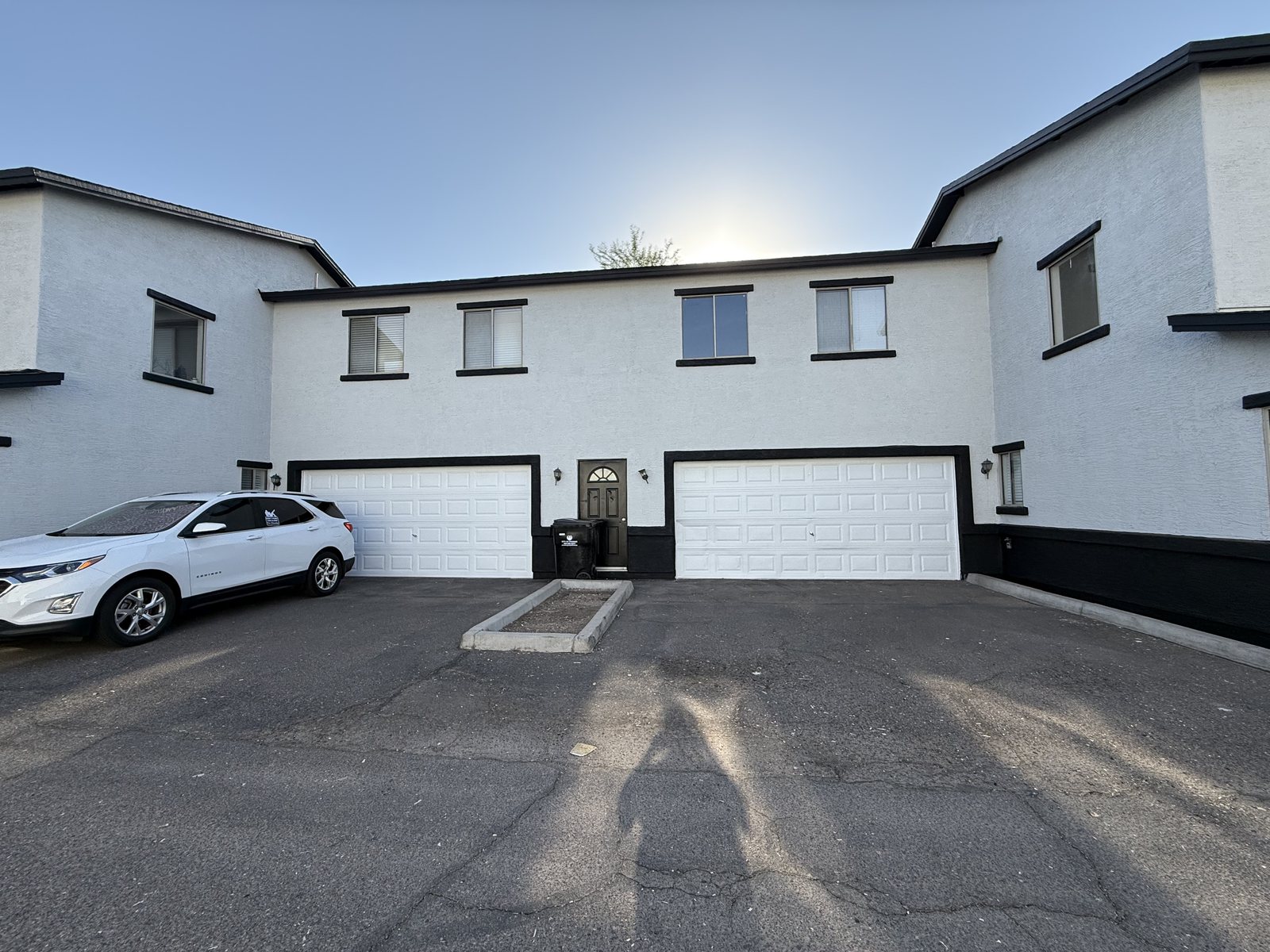 White townhomes with black trim and skirt painted by Happy Brush Painters &mdash; garage courtyard elevation